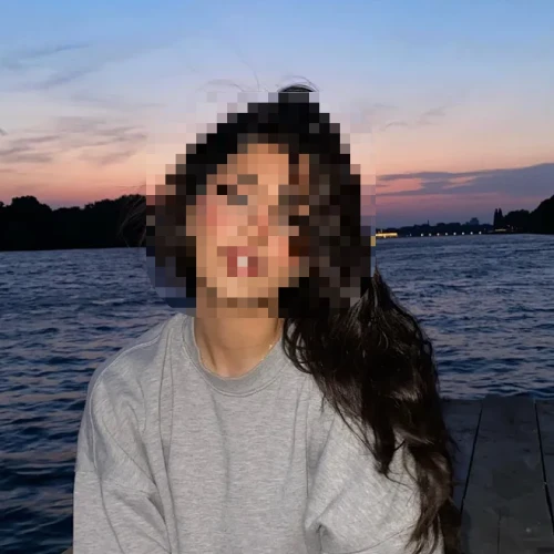 Woman by the water with her face pixelated