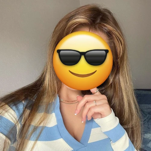 Woman taking a selfie with her face covered by a sunglasses emoji